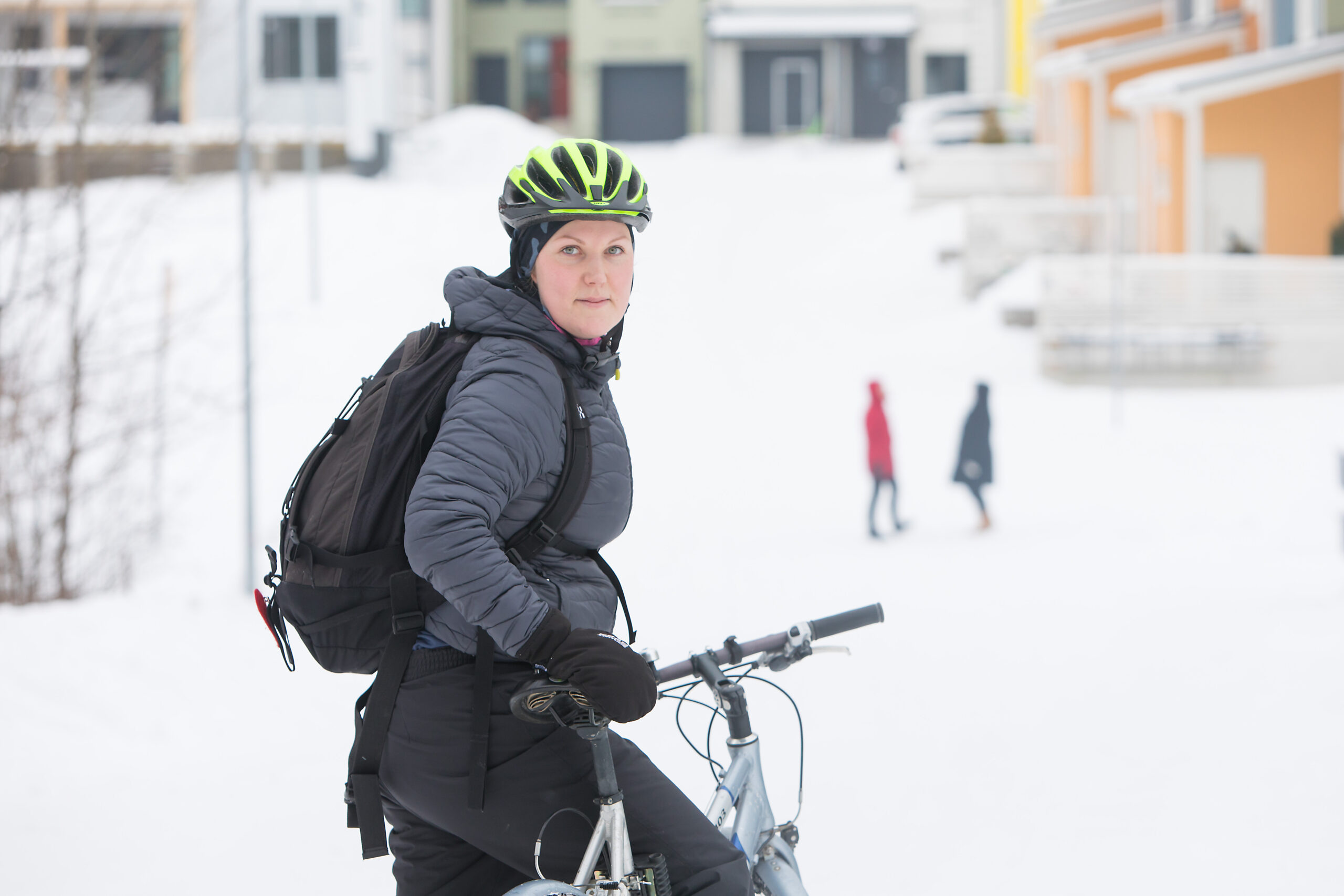 Pyöräilijä pysähdykissä lumisessa talvimaisemassa.